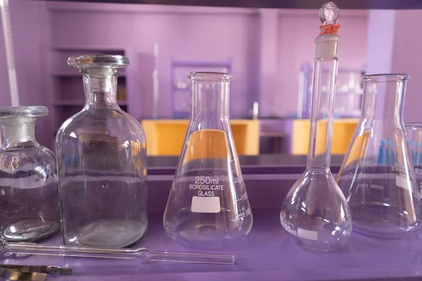 Primer plano de artículos de vidrio de laboratorio bien dispuestos o tubos de vidrio vacíos en el laboratorio de ciencias vacías en la universidad . — Foto de Stock