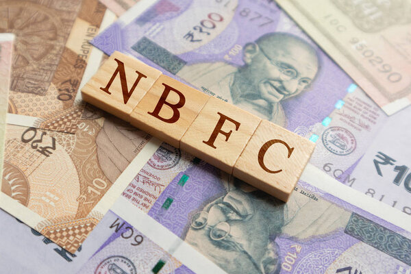 NBFC деревянными буквами на индийской валюте
