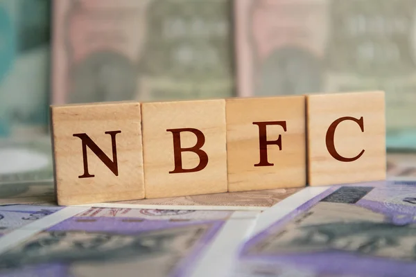 NBFC in wooden block letters on indian currency — Stock Photo, Image