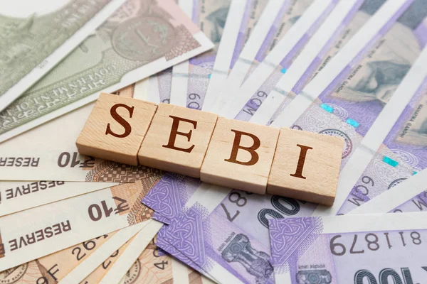 SEBI in houten blokletters op Indiase valuta. — Stockfoto