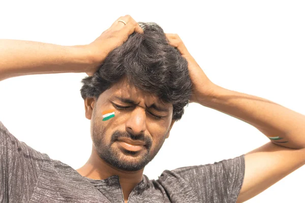 Nahaufnahme, trauriger Ausdruck eines männlichen indischen Cricket-Sportfans mit gemalter indischer Flagge im Gesicht, isolierter Hintergrund. — Stockfoto