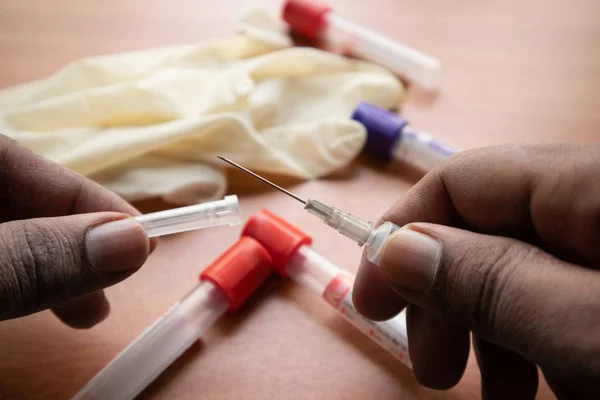 Doctor mână exploatație seringă, pentru a obține proba de sânge în laborator cu Plain Clot Activators ca fundal în India . — Fotografie, imagine de stoc