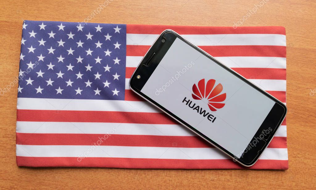 Maski, India - June 21, 2019: Huawei logo on screen of Mobile on US flag.