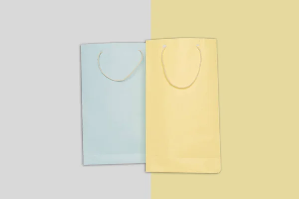 Bolso de papel de compras de color azul claro y amarillo sobre fondo colorido . — Foto de Stock