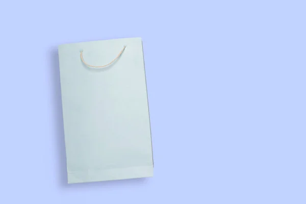 Bolso de papel de compras de color azul claro sobre fondo de color azul con espacio de copia . — Foto de Stock