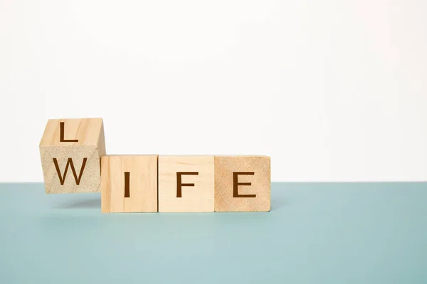 Przerzucanie jednego drewnianego sześcianu, aby zmienić słowo życie na żonę na neutralnym tle — Zdjęcie stockowe