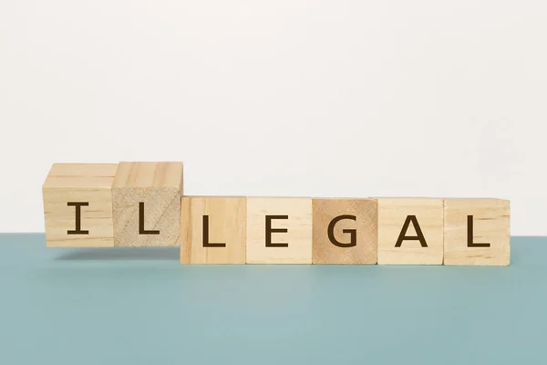 Capovolgere due cubi di legno per cambiare la parola Legale a illegale su sfondo neutro — Foto Stock