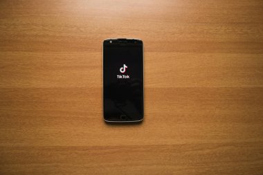 Maski, Hindistan - 7 Temmuz 2019 - Ahşap masa üzerinde akıllı telefon ekranında Tik Tok sosyal medya uygulaması.