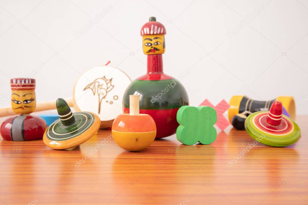 Colourful different types of GI Tagged channapatna toys on table with isolated background.