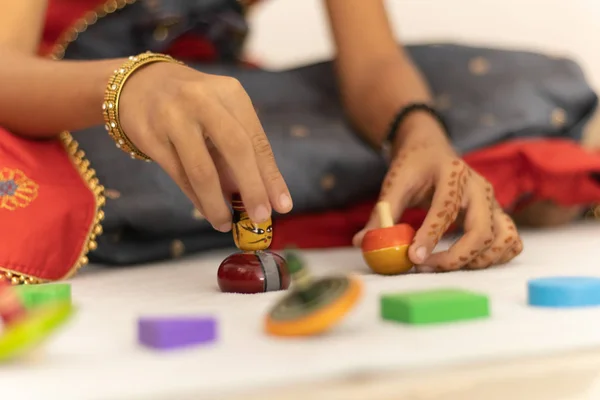 Concentrarsi sulle mani della bambina carina che gioca con i giocattoli in legno indiano channapatna nella stanza — Foto Stock