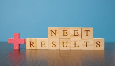 NEET Results a medical Exam conducted at India in wooden block leters on table. clipart