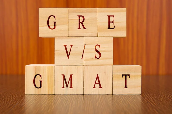 Concept de GRE vs GMAT Différences d'examen dans les lettres moulées en bois sur la table . — Photo