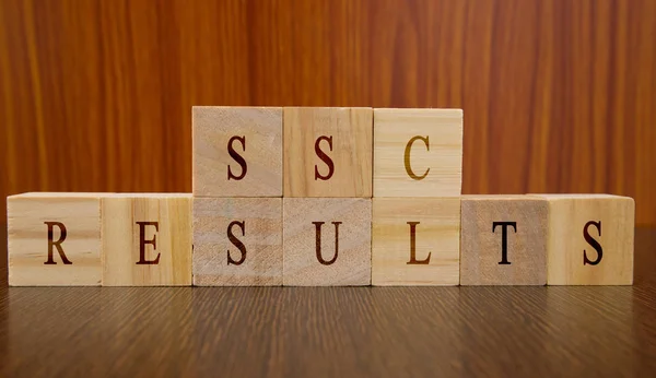 Concept of SSC exam Results conducted in India, in wooden block letters on table