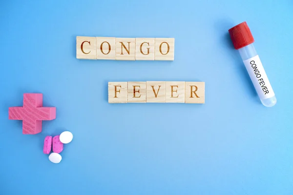 Cocept of Crimean Congo hemorrhagic fever, congo Fever or CCHF in wooden block letters with laboratory tubes.