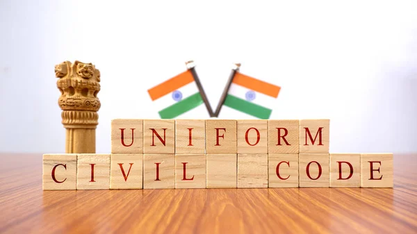 Concept of One law for all called Uniform Civil code or UCC in Indian constitution in wooden block letters and Indian flag as a background.