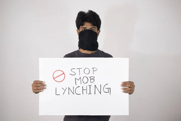 Young man protesting against the Mob lynching by holding Placard showing of Stop Mob Lynching on isolated background.