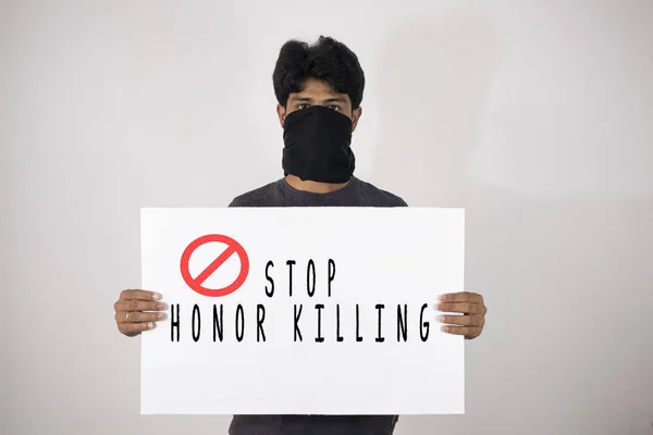 Young man protesting against the Honor Killing by holding Placard showing of Stop Honour Killing on isolated background