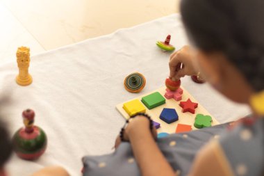 Odada Hint ahşap channapatna oyuncaklar ile oynayan sevimli küçük çocuk kız ellere odaklanın