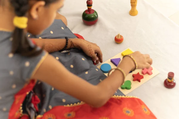 Carino bambina che gioca con i giocattoli di legno indiano channapatna nella stanza — Foto Stock