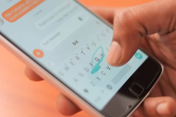 Close-up van een man hand typen met behulp van Swype keyboard op mobiele Smart Phone. — Stockfoto