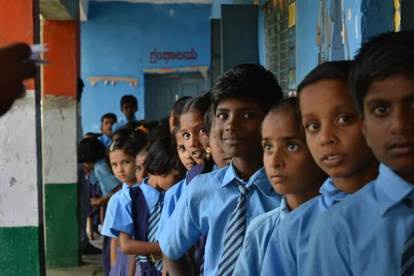 Мерналь, Карнатака, Індія 25 липня, 2019: уряд школи діти веселяться, стоячи в Que. — стокове фото