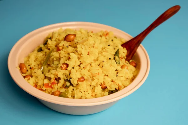 Listo para comer Poha fresca y comida india de la mañana comida rápida en un tazón con cuchara — Foto de Stock