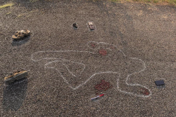 Crime scene chalk outline of victim dead body on Road with blood and evidences, Concept of murder investigation.