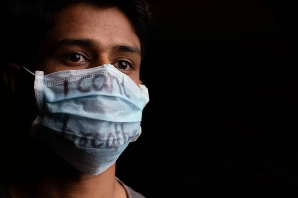 Молодой человек с надписью "Я не могу дышать" на медицинской маске с копировальным пространством. Концепция протестов против прав человека чернокожих в США — стоковое фото
