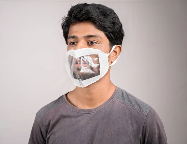 young man weared with transparent Medical face mask, to help hearing imperimeant or deaf people to understand lipreading during coronavirus or covid-19 outbreak