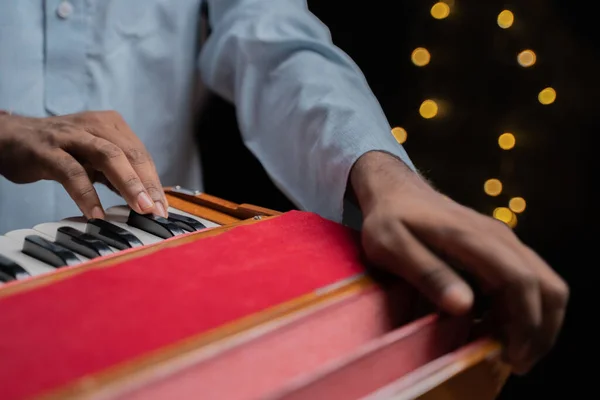 Close up of Hands playing Harmonium an Indian classical music instrument.