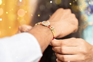 Ellerin kapalı, rakhi 'yi bağlayan kız kardeş, festival ya da tören sırasında Raksha bandhan' ın bileklerine bağlanması - Rakshabandhan Hindistan 'ın dört bir yanında özverili bir sevgi ya da kardeşler arasındaki ilişki olarak kutlandı