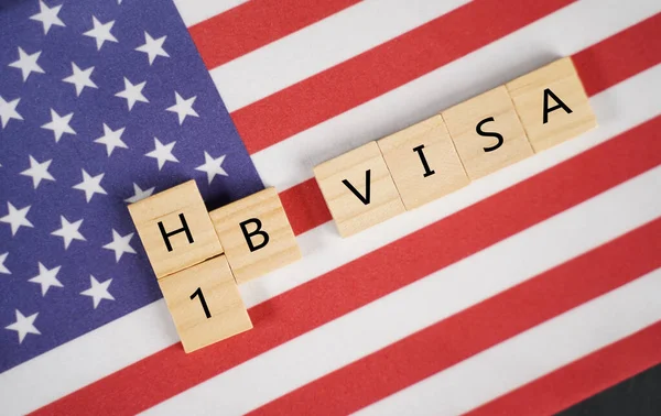 Concept van H1b Visa voor buitenlandse werknemers tonen houten letters met Amerikaanse of Amerikaanse vlag als achtergrond — Stockfoto