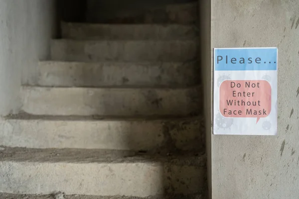 signage board showing of do not enter without face mask at industrial workplace due to coronavirus or covid-19 pandamic - concept of industry or business reopen and new normal lifestyle.