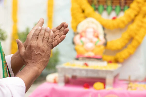 Primer plano de las manos del Anciano ofreciendo Bhajan o himno frente al Señor Ganesha Ídolo aplaudiendo durante Ganesha o vinayaka Chaturthi festvial ceremonia en casa. —  Fotos de Stock