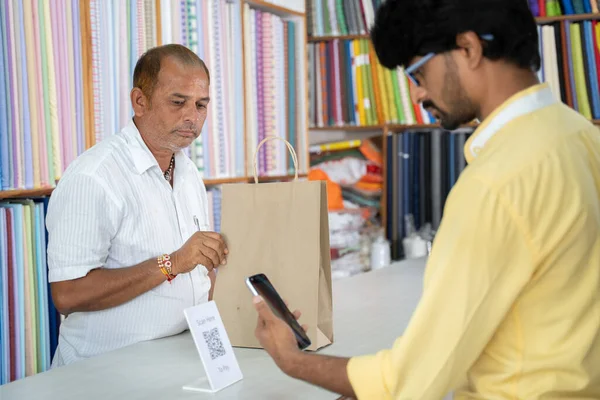 Client utilisant le balayage numérique de méthode de paiement pour payer au magasin de tissu pour envoyer de l'argent concept de paiement numérique ou sans contact, e-transfert, technologie et mode de vie. — Photo