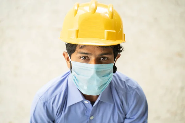 Visão de alto ângulo do trabalhador da construção em máscara médica olhando para cima em confiante - conceito de negócios, indústria reaberta e covid-19 medidas de segurança no local de trabalho. — Fotografia de Stock