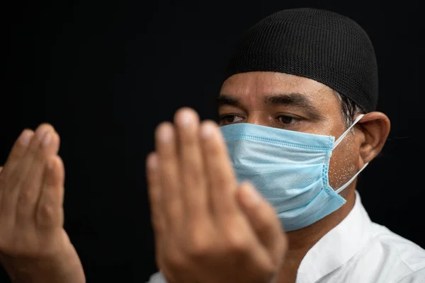 Tıbbi maskeli Müslüman adam Salah 'ı hazırlıyor ya da gözlerini kapayarak dua ediyor.. — Stok fotoğraf