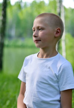 beyaz bir t-shirt genç çocuk bir yaz d ormanda yürüyor