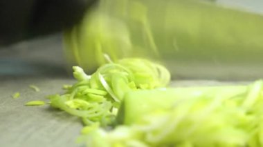 Kesme tahtasında taze taze soğan doğramak.