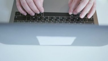 Bir dizüstü bilgisayarda yazarak eller. Arkadan aydınlatmalı. Yanal dolly.