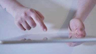 Bu yakından atış tipi dokunmatik ekran tablet cihaz onun elinde tutan genç kadın görebilirsiniz. O ekran resimler için arama yaparken kaydırma veya haber okuma online feed.