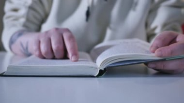 El ve kitap: bir kitap okuma ve parmaklarını çizgisinde tutarak. Bir kadın eli bir kitap tutan ve parmaklarını okuma sırasında sayfa boyunca hareket eder. Kitap okuyucu tutar