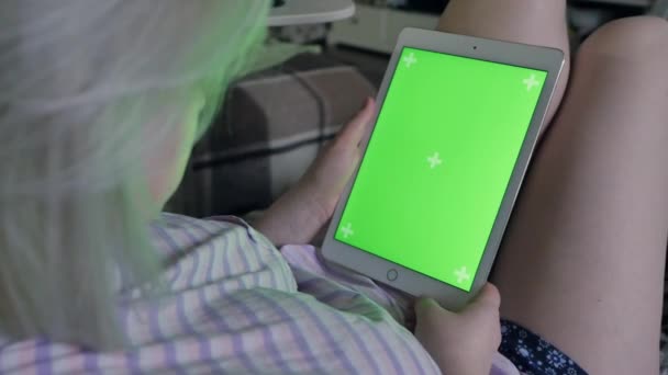 坐在白色沙发上的一名妇女使用带有绿色屏幕的平板电脑的室内镜头 — 图库视频影像