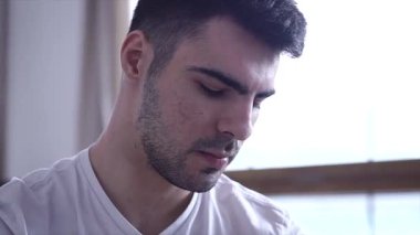 Yakın çekim yüz genç bir adamın dairesinde bir kitap okuma 