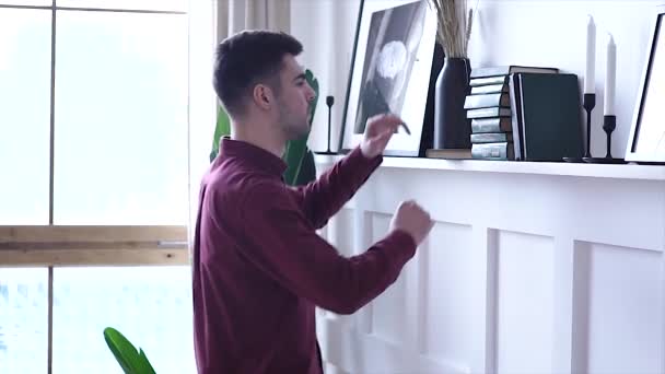 Красивий Молодий Чоловік Вибирає Книгу Книжкової Шафи Читаючи Вдома Своїй — стокове відео