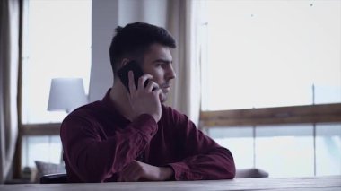 genç adam sandalye kullanım telefon adam iş ev Internet teknolojisi cep cep telefonu mutlu çocuk erkek online smartphone Gadget'ı ağır çekim portre yakın çekim evde oturmak