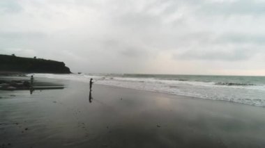 Altın gün doğumunda elinde profesyonel bir oltayla kıyıdan balık yakalayan bir balıkçı. Gün batımında sahilde balık tutan adam