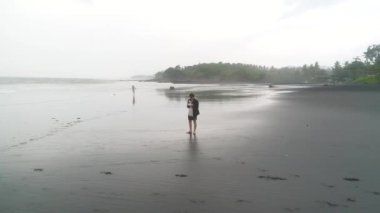 İzlanda 'da volkanik siyah kumsalda özçekim yapan maceraperest bir adamın görüntüsü.. 