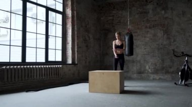 Fit Athletic Woman Does Box Jumps in the Deserted Factory Gym