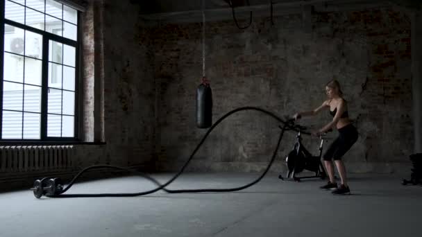 在健身房锻炼的年轻的成年女孩练习战斗绳索练习 — 图库视频影像